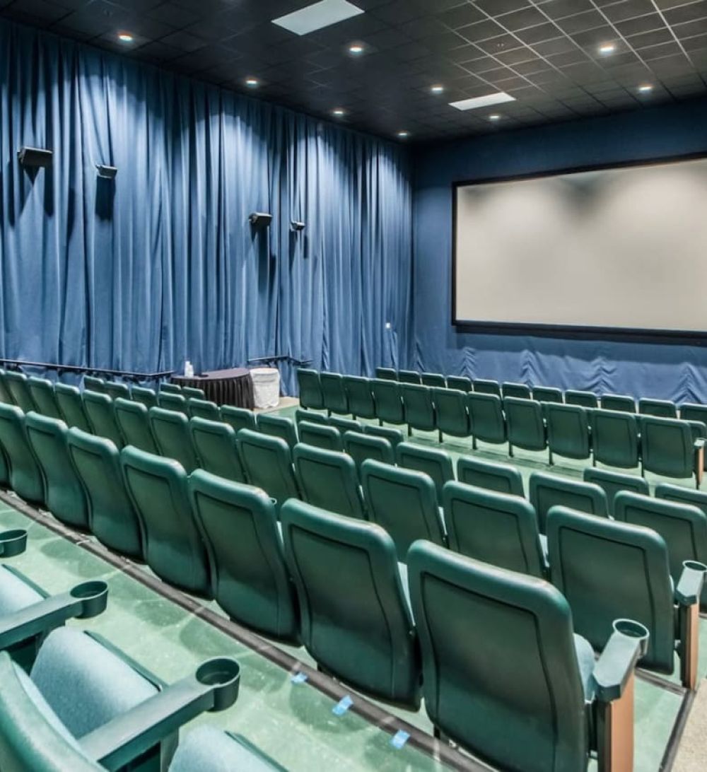 Majestic Beach Resort’s on-site movie theater featuring stadium seating, large projection screen, and a private cinema-style atmosphere.