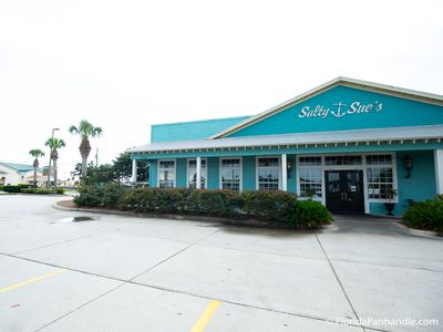 Front view of Salty Sue’s Restaurant in Panama City Beach, featuring turquoise exterior and large windows.