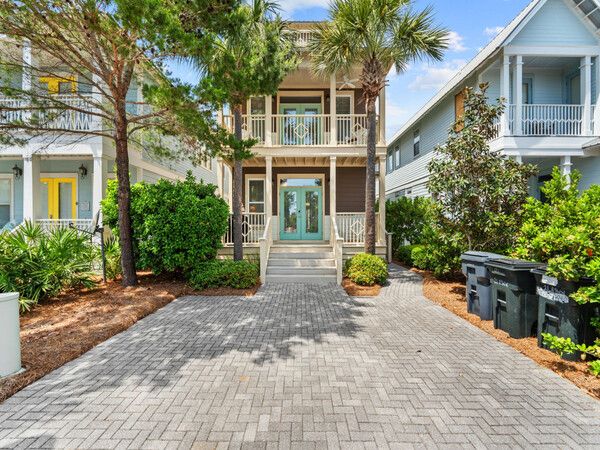 Exterior front view of Seacrest Beach rental home with double porches and brick driveway.