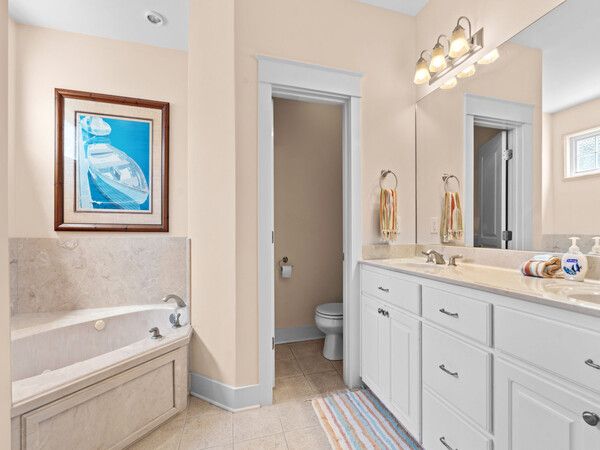 Lifeguard-style Seacrest Beach entrance sign surrounded by palm trees and landscaping.