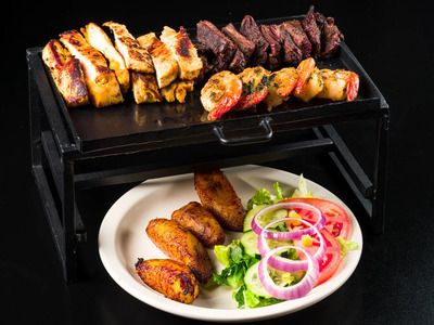 Mixed grill platter with chicken, steak, shrimp, plantains, and fresh salad served at Colombian Grill House in Panama City Beach.