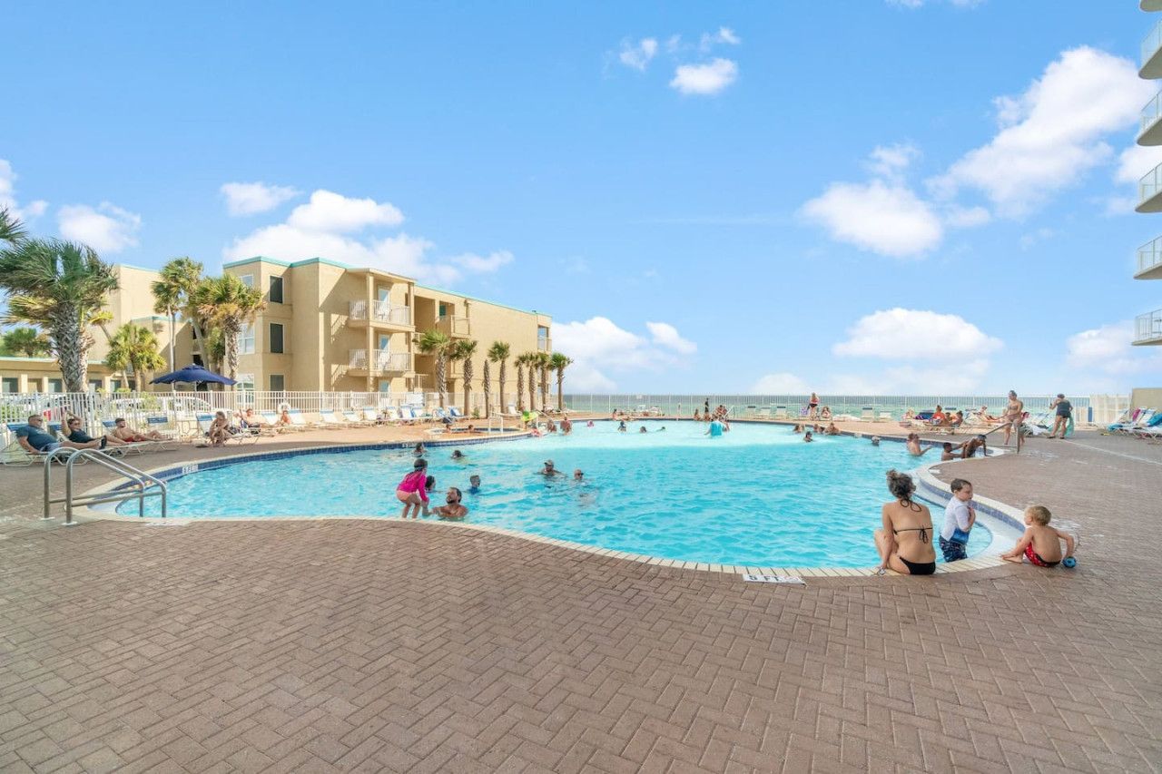 Guests enjoying the large Gulf-front outdoor pool at Tidewater Beach Resort on a sunny day.