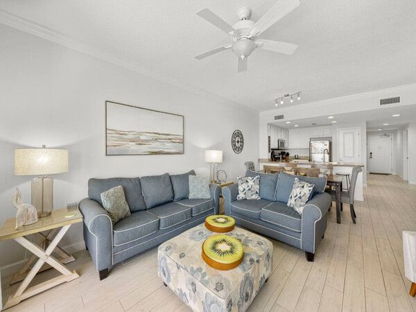 Spacious living room with coastal décor and floor-to-ceiling Gulf views at Grandview East condo.