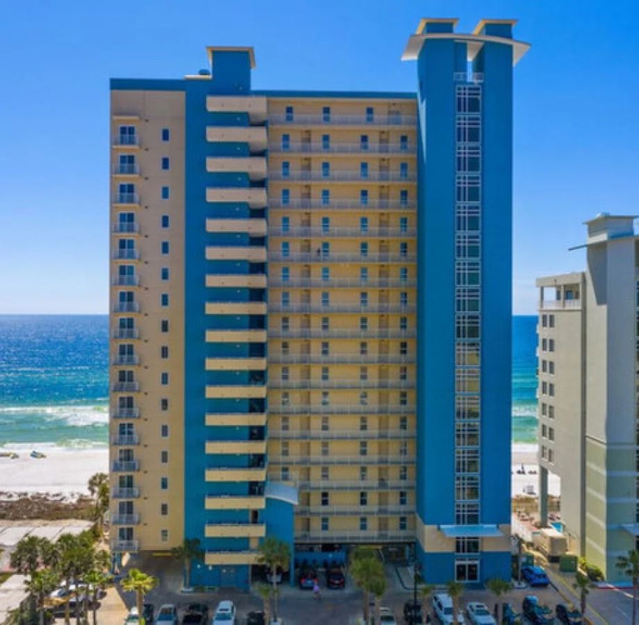 Grandview East Resort oceanfront high-rise with balconies overlooking white sand beach and the Gulf of Mexico on a clear sunny day.
