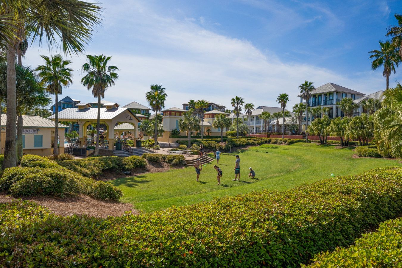 Fully equipped kitchen featuring stainless steel appliances, wooden cabinetry, pendant lighting, and a large breakfast bar with seating in a Seacrest Beach rental home.