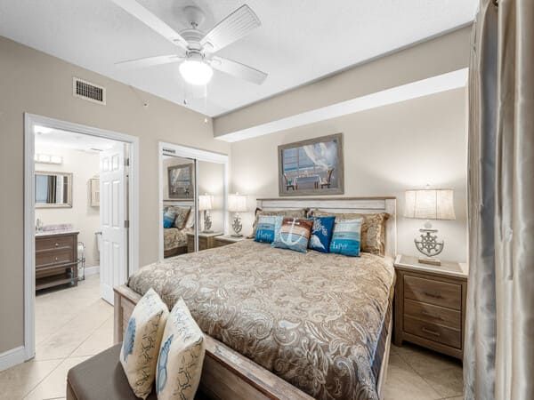 Cozy master bedroom with neutral decor and private bathroom in a Majestic Beach Resort condo.