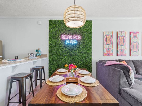 Dining area with neon “Relax PCB” sign and coastal décor in an Ocean Ritz beachfront condo.