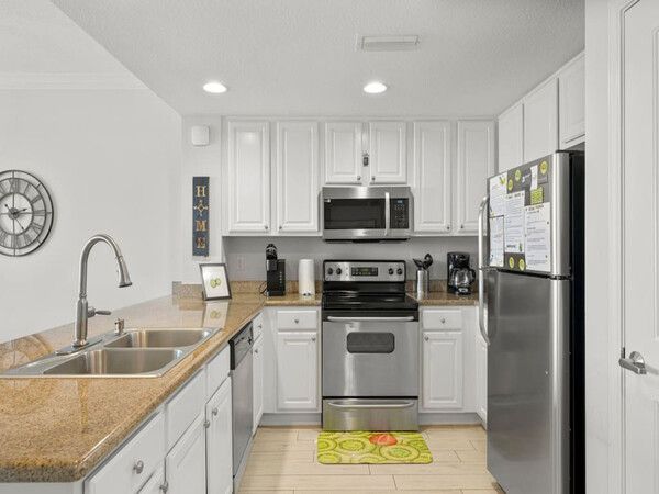 Fully equipped modern kitchen at Grandview East condo with stainless steel appliances and granite countertops.