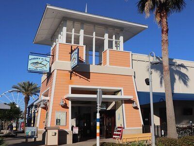 Front entrance of Angry Tuna Seafood Company at Pier Park in Panama City Beach, featuring its coastal-style architecture.