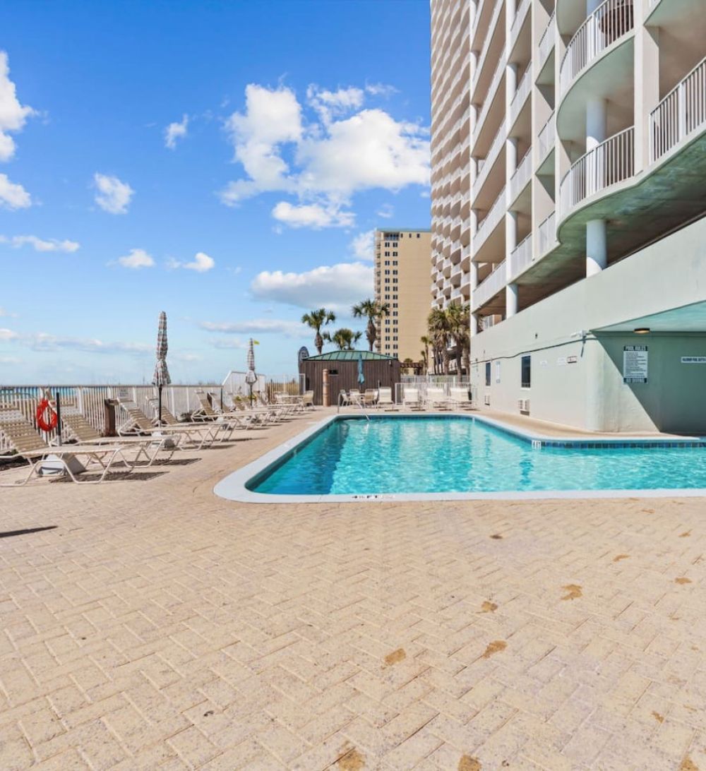 Ocean Ritz beachfront outdoor pool with lounge chairs, ocean views, and sunny blue skies in Panama City Beach.