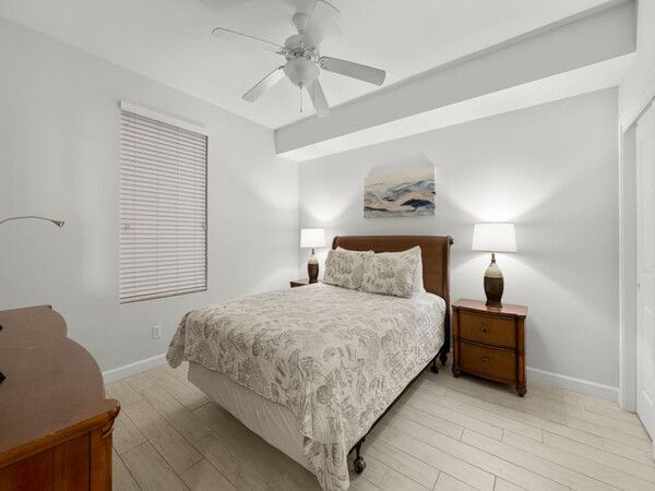 Cozy guest bedroom with a queen bed, warm lighting, and modern coastal décor.