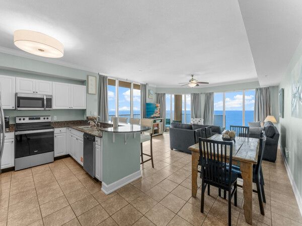 Spacious open-concept kitchen and living area with floor-to-ceiling Gulf views inside a Tidewater Beach Resort condo.