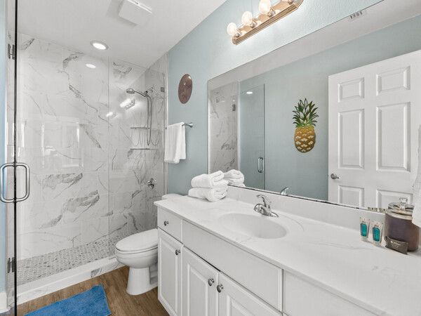 Updated bathroom at a Tidewater Beach Resort condo with a walk-in glass shower, double vanity, and clean modern design.