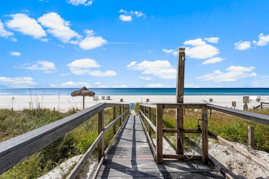 Private wooden boardwalk leading directly to the white-sand beach and Gulf of Mexico at Grandview East Resort.