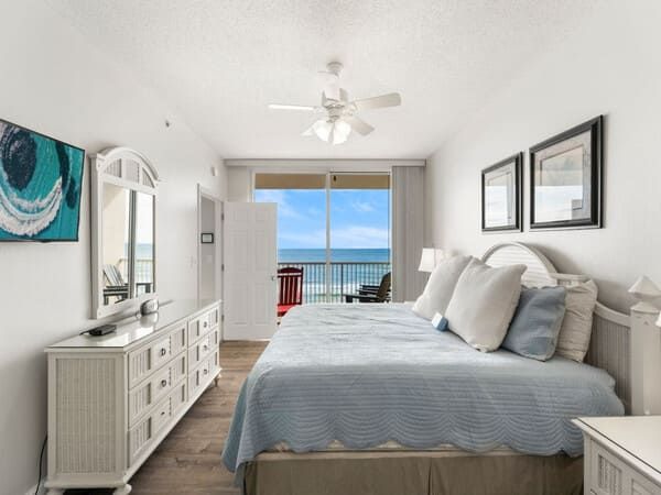 Bright master bedroom with king bed and direct balcony access overlooking the Gulf at Majestic Beach Resort.