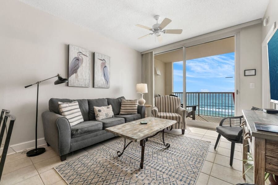 Living room at Majestic Beach Resort with balcony access, ocean views, and coastal décor.