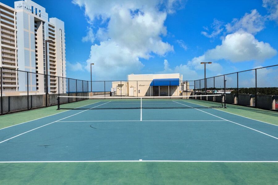 Rooftop tennis court at an oceanfront condominium with city and ocean views.