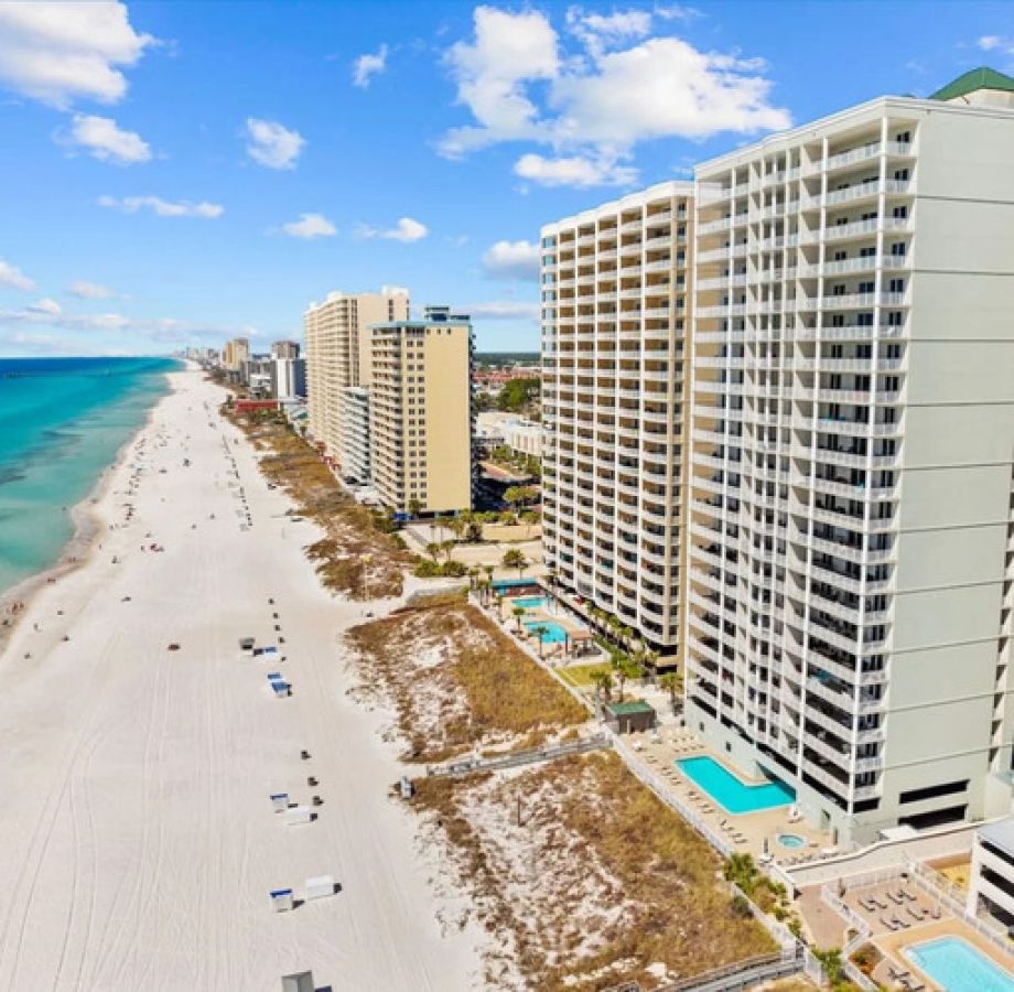 Aerial view of Ocean Ritz Resort and the white-sand coastline of Panama City Beach on a sunny day.