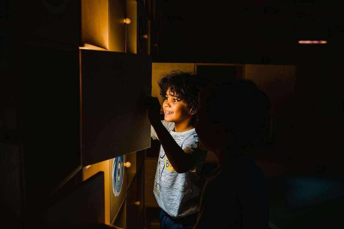 Two boys engage with a glowing educational display, highlighting curiosity and learning.