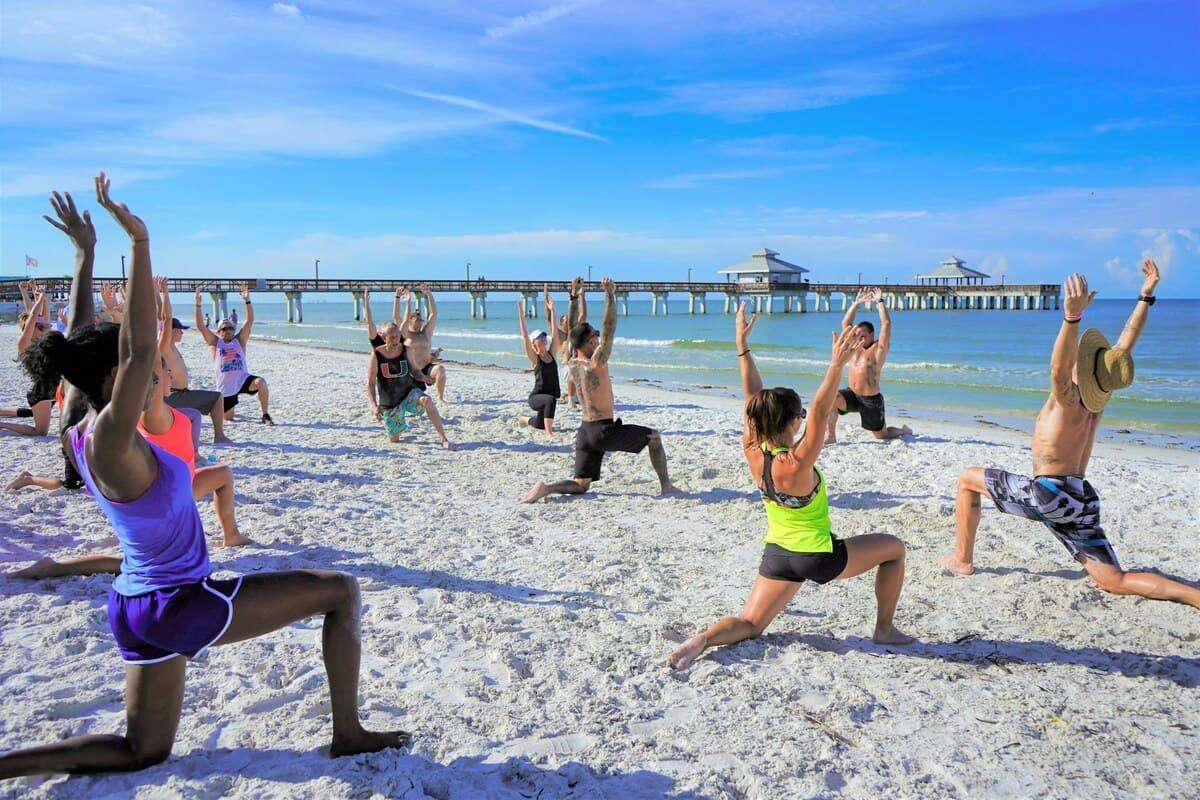 people doing yoga at the beach