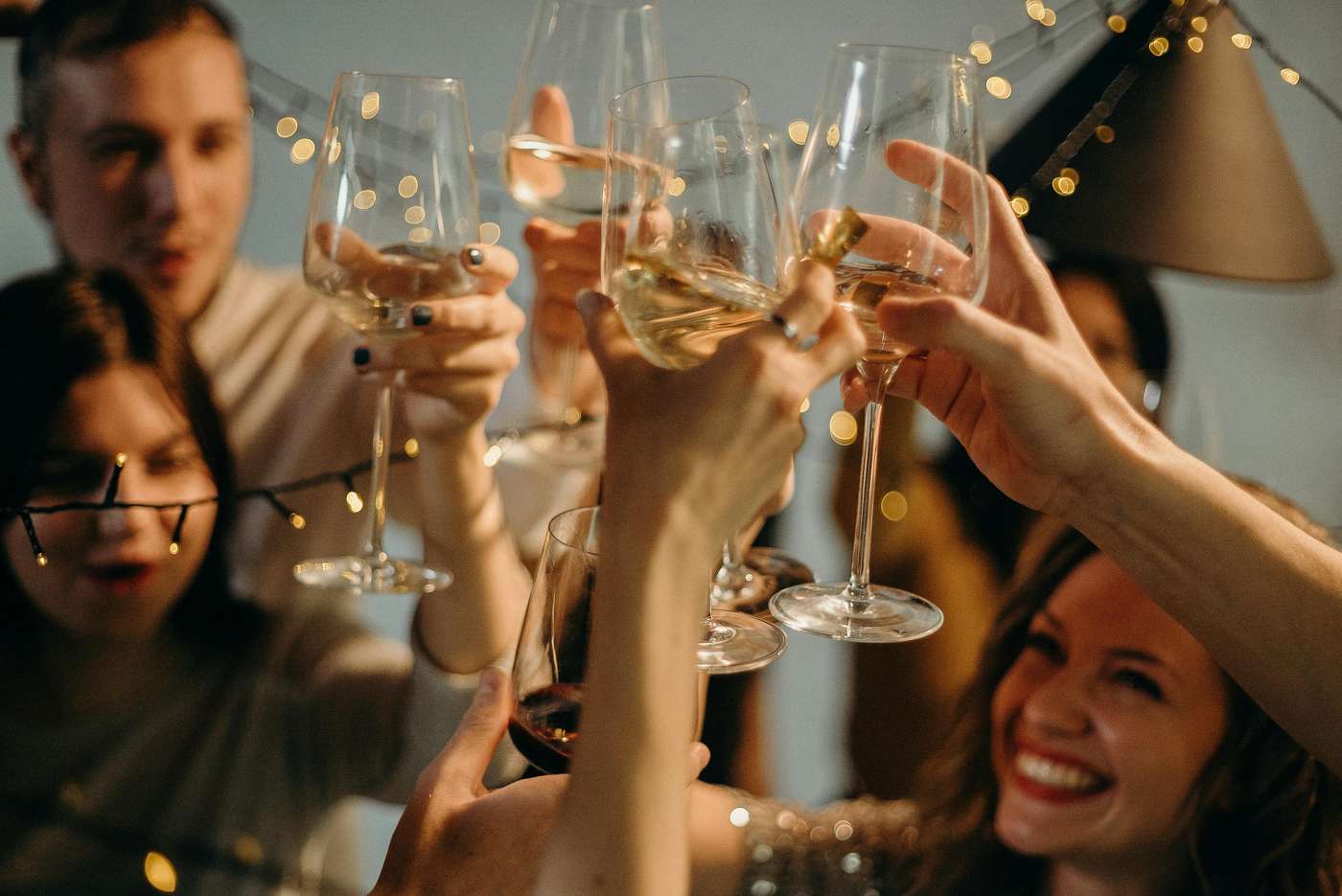 A group of friends joyfully toasting with champagne glasses at a festive celebration.